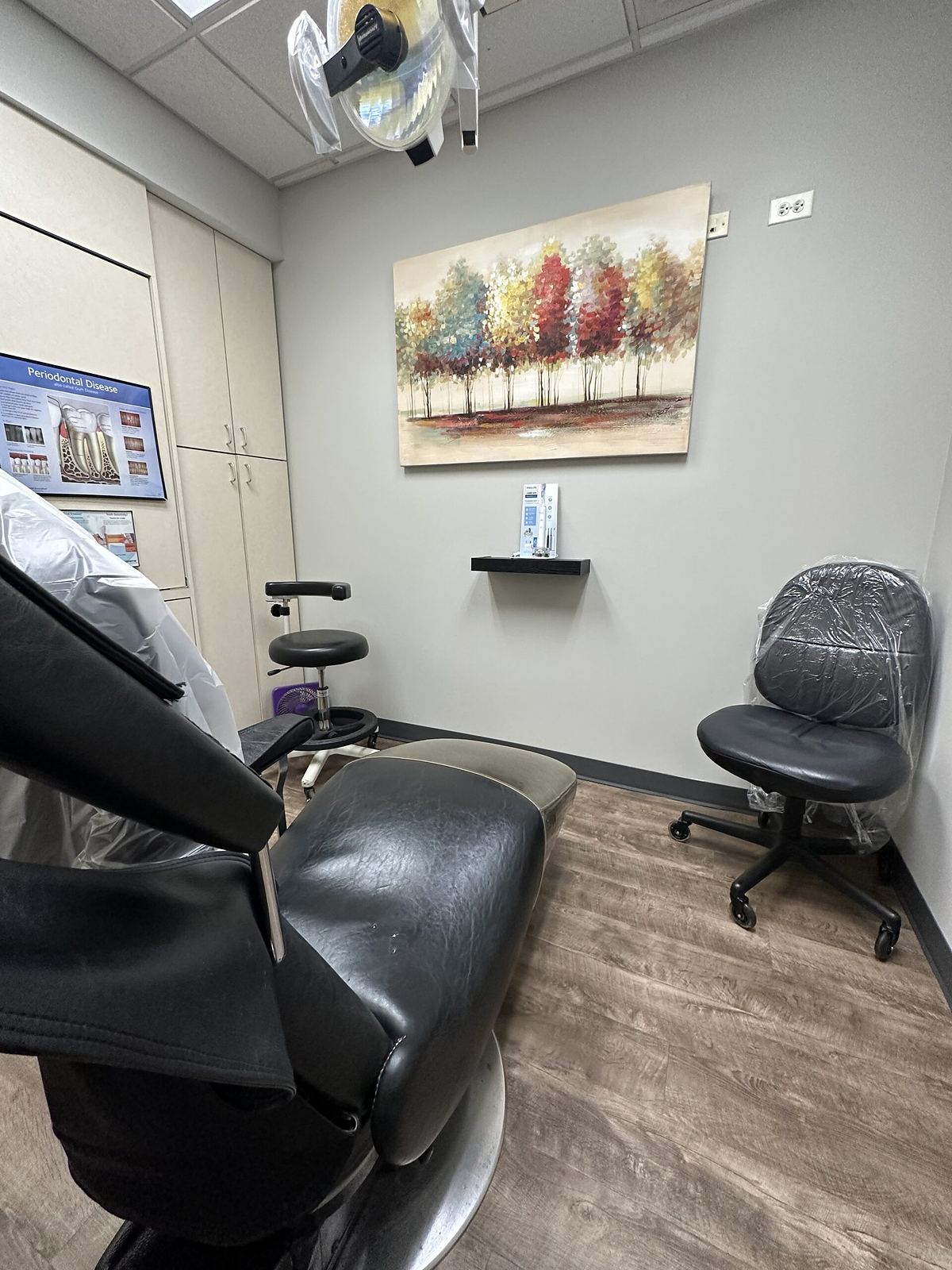 A treatment room at Worth Palos Dentistry, with the dental chair, overhead light and an assistant's stool